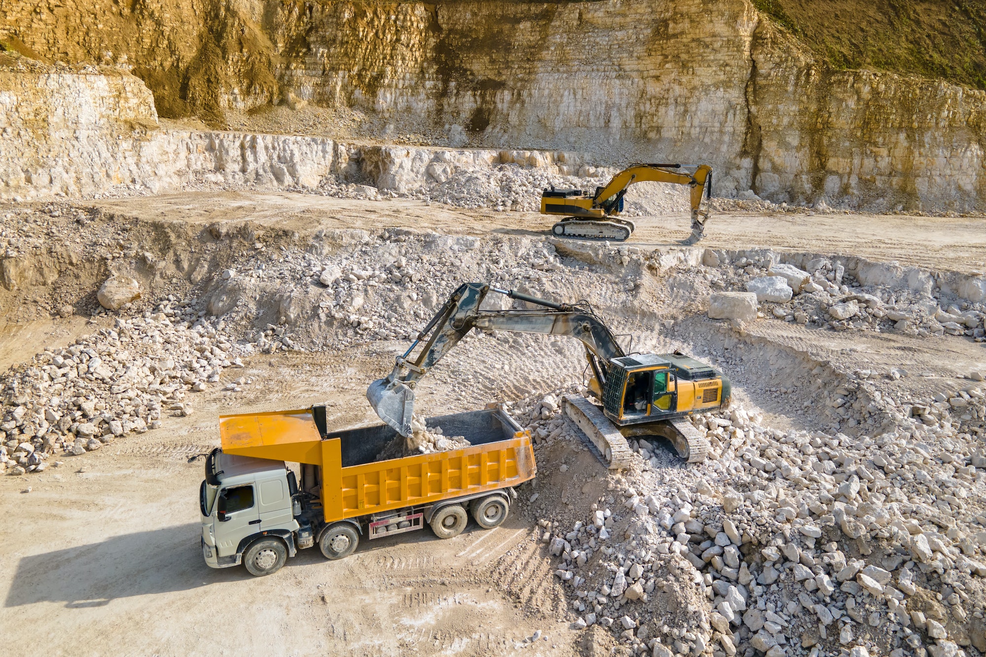 open-pit-mining-of-construction-sand-stone-materials-with-excavators-and-dump-trucks.jpg